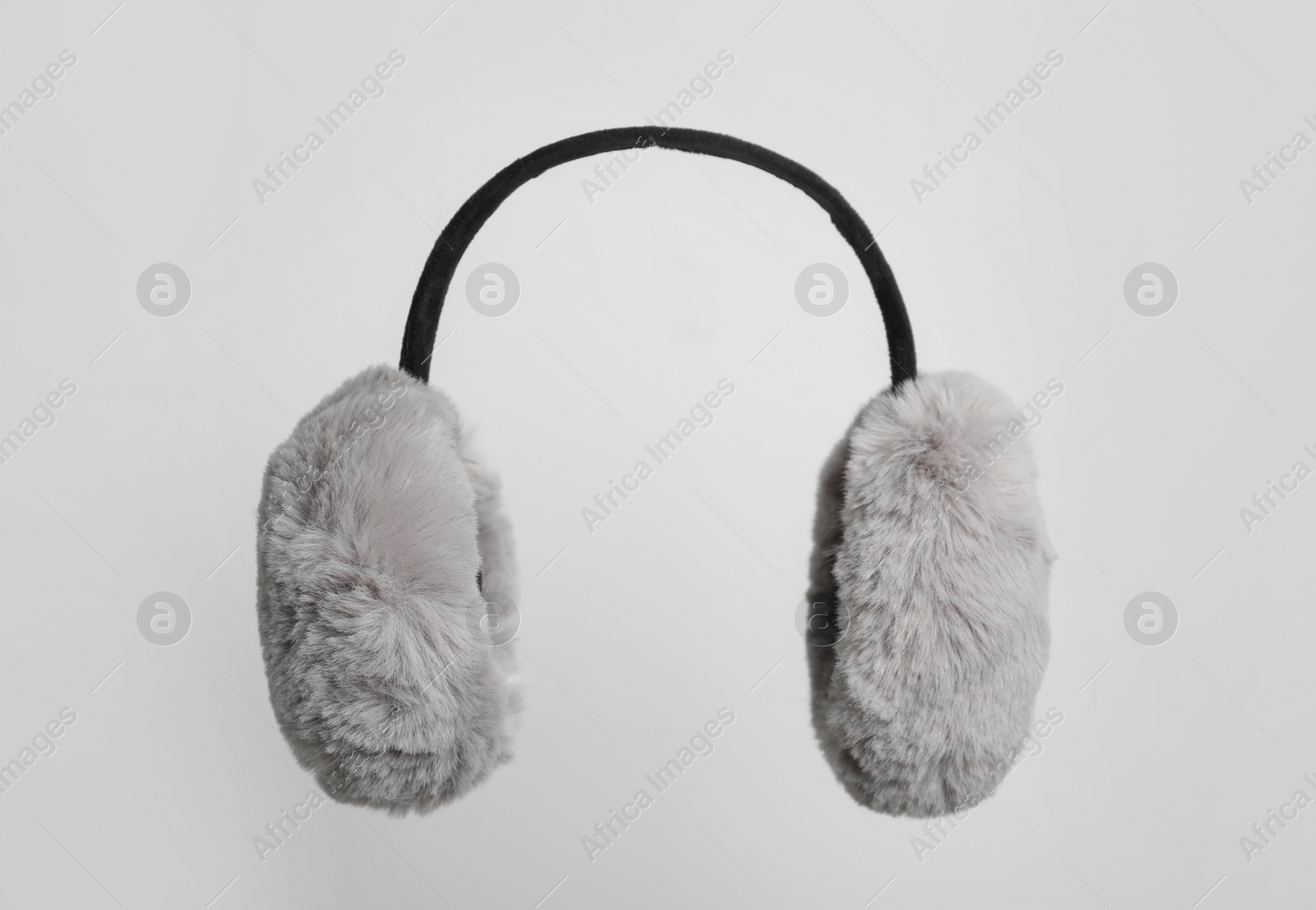 Photo of Fluffy earmuffs on white background. Stylish winter accessory