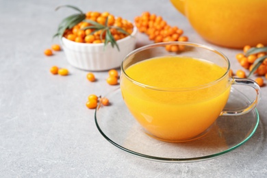 Photo of Fresh sea buckthorn tea on light table, closeup