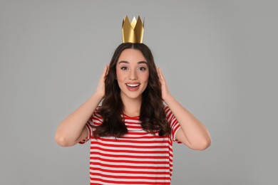 Photo of Beautiful young woman with princess crown on grey background