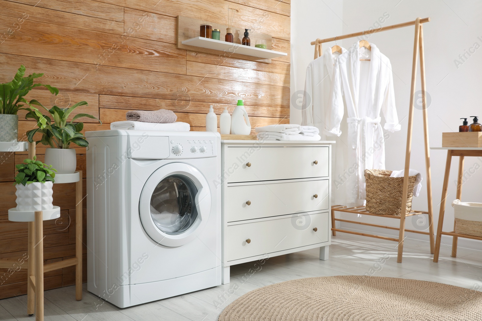 Photo of Laundry room interior with washing machine and stylish furniture