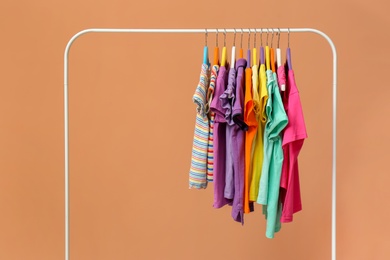 Photo of Rack with stylish children clothes on beige background