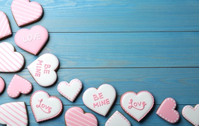 Photo of Valentine's day cookies on blue wooden table, flat lay. Space for text