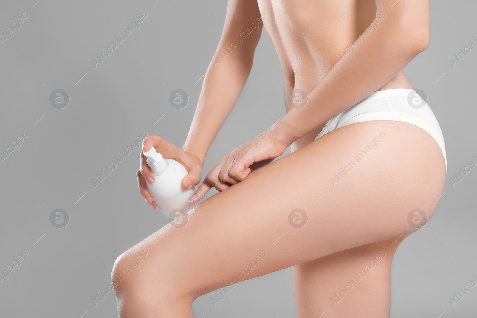 Photo of Young woman with bottle of body cream on color background