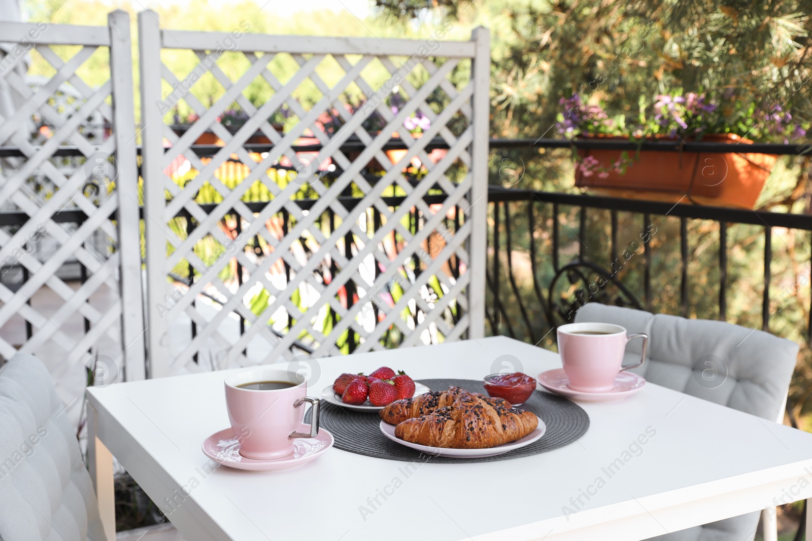 Outdoor breakfast with tea and croissants on white table on terrace Photo of Outdoor breakfast with tea and croissants on white table on terrace