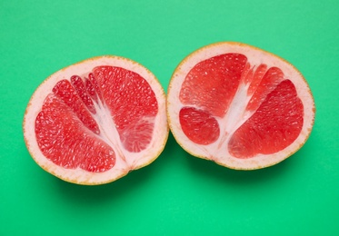 Photo of Delicious fresh cut grapefruit on green background, flat lay