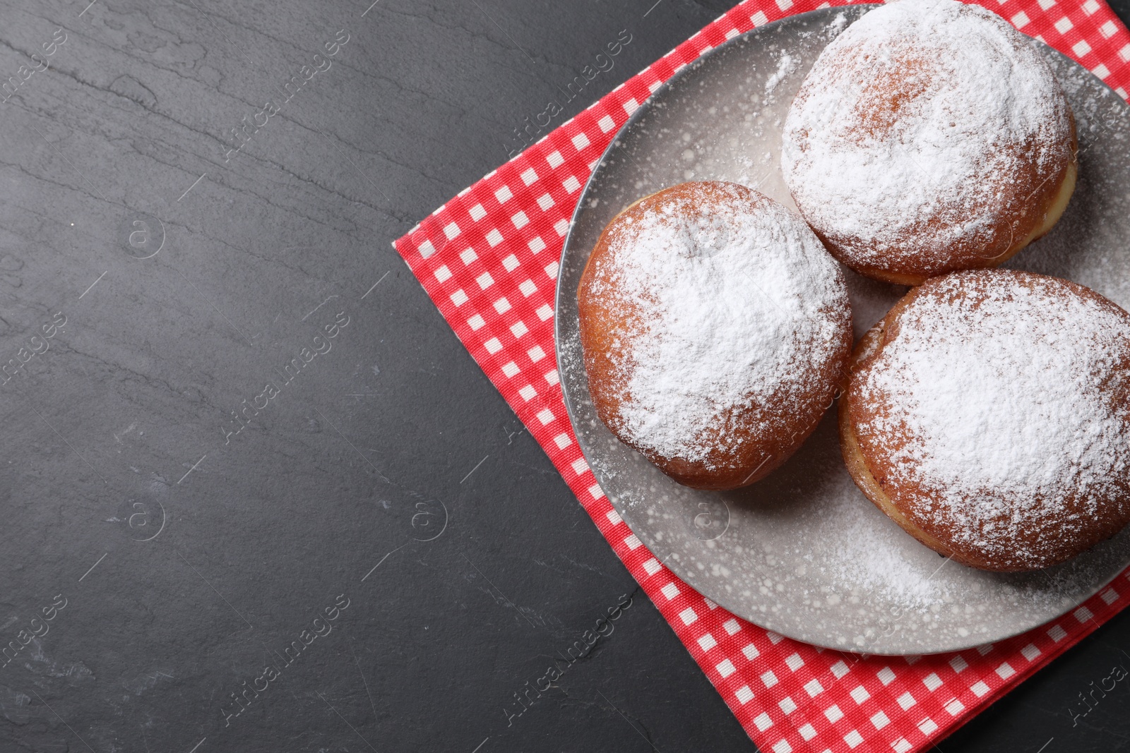 Photo of Delicious sweet buns on dark gray table, top view. Space for text