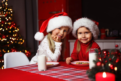 Photo of Cute little children at table in dining room. Christmas time