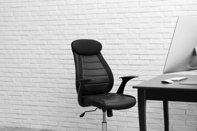 Photo of Stylish workplace interior with modern office chair