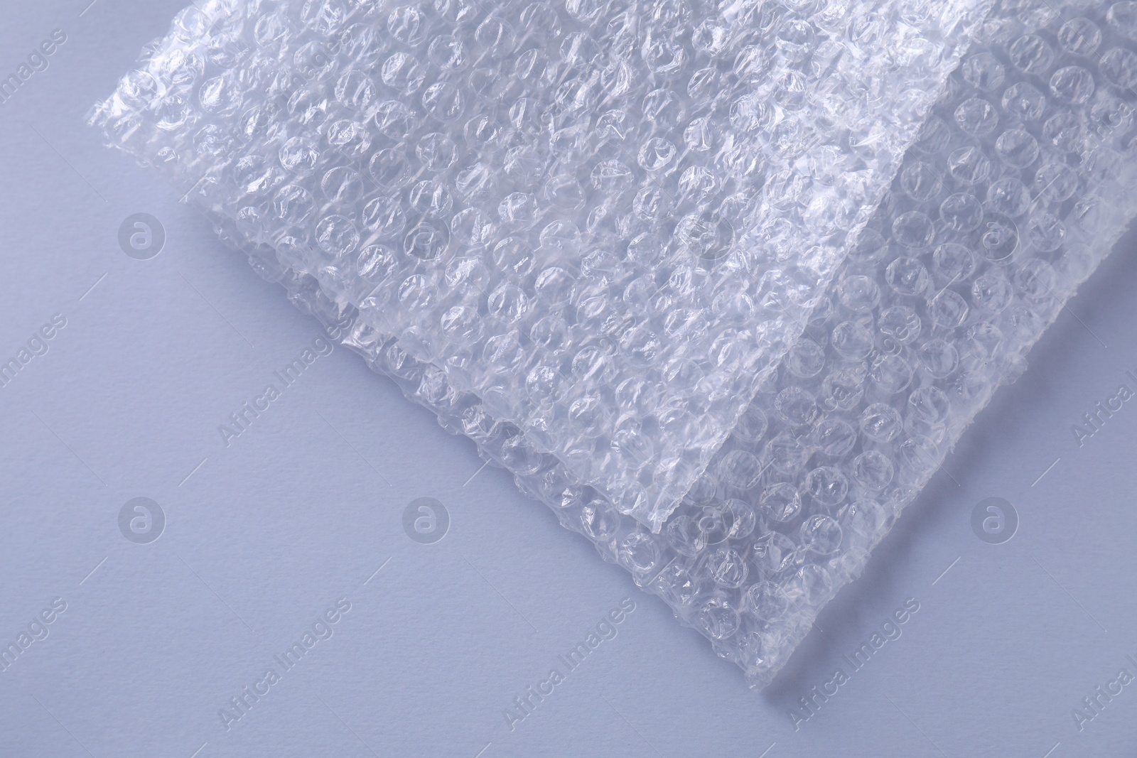 Photo of Transparent bubble wrap on gray background, top view. Space for text