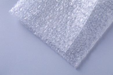 Photo of Transparent bubble wrap on gray background, top view. Space for text