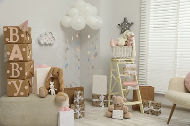 Photo of Baby shower party. Festive decor, gift boxes and toys in stylish room