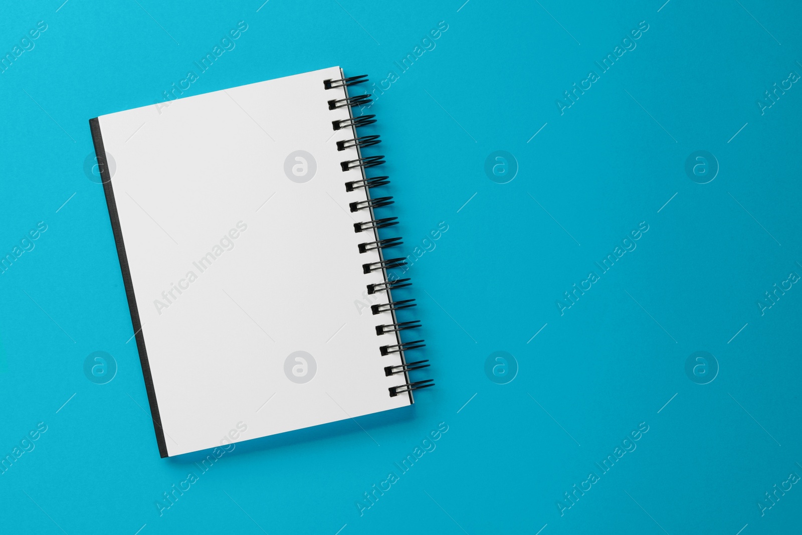 Photo of Blank notebook on light blue background, top view. Space for text