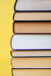 Photo of Collection of hardcover books on yellow background