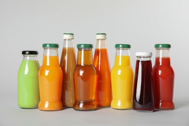 Bottles with different drinks on color background