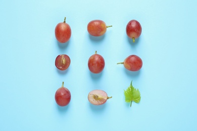 Flat lay composition with fresh ripe juicy grapes on light blue background