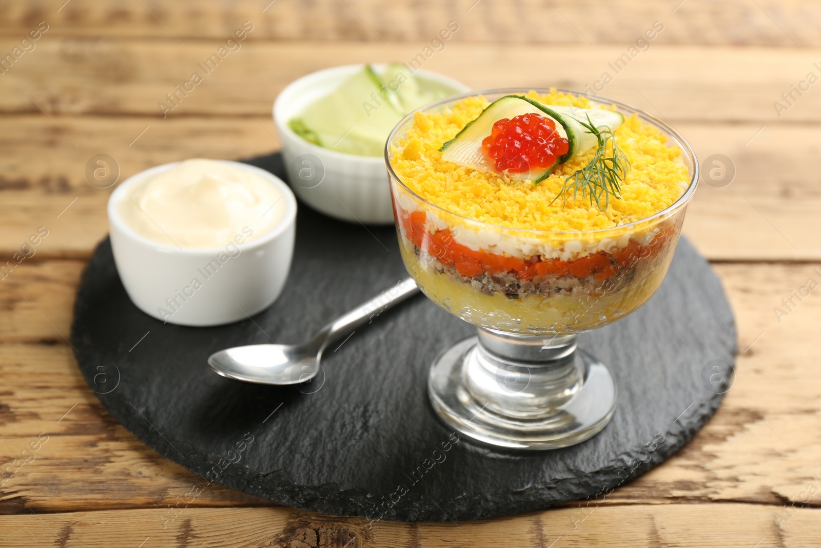 Photo of Traditional russian salad Mimosa served on wooden table