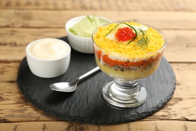 Traditional russian salad Mimosa served on wooden table