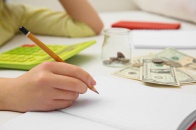 Young woman counting money on sofa indoors, closeup