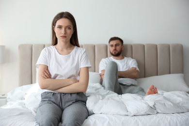 Unhappy couple with problems in relationship on bed at home