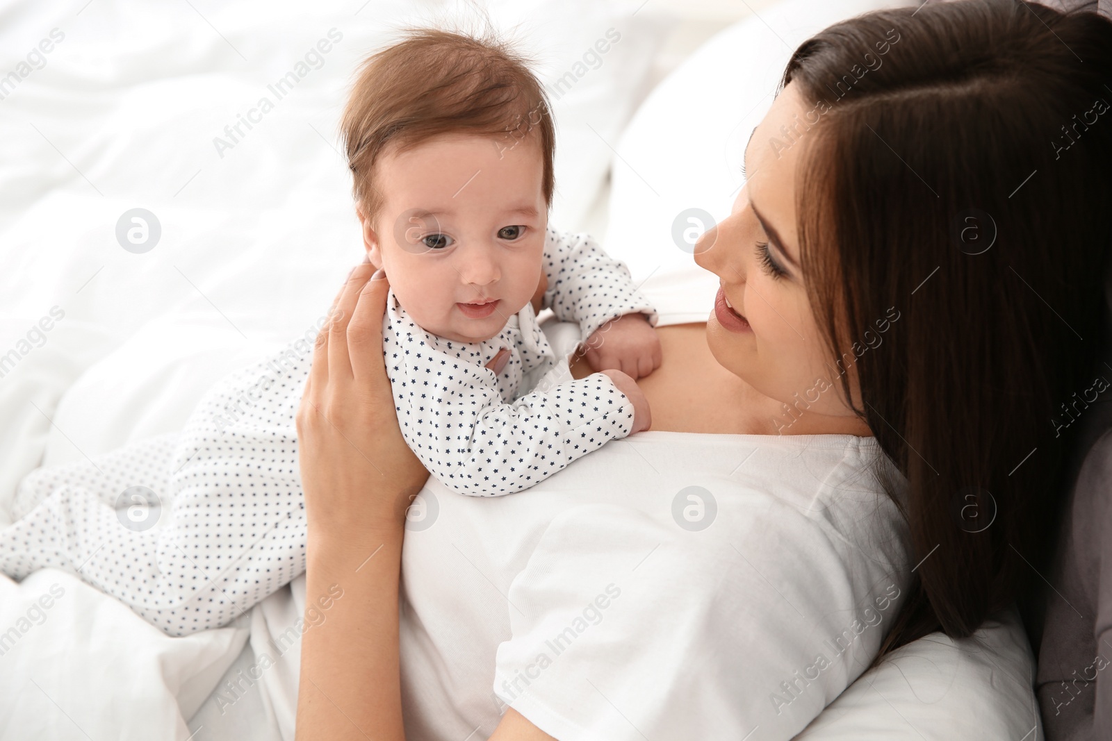 Photo of Happy woman with her cute baby on bed