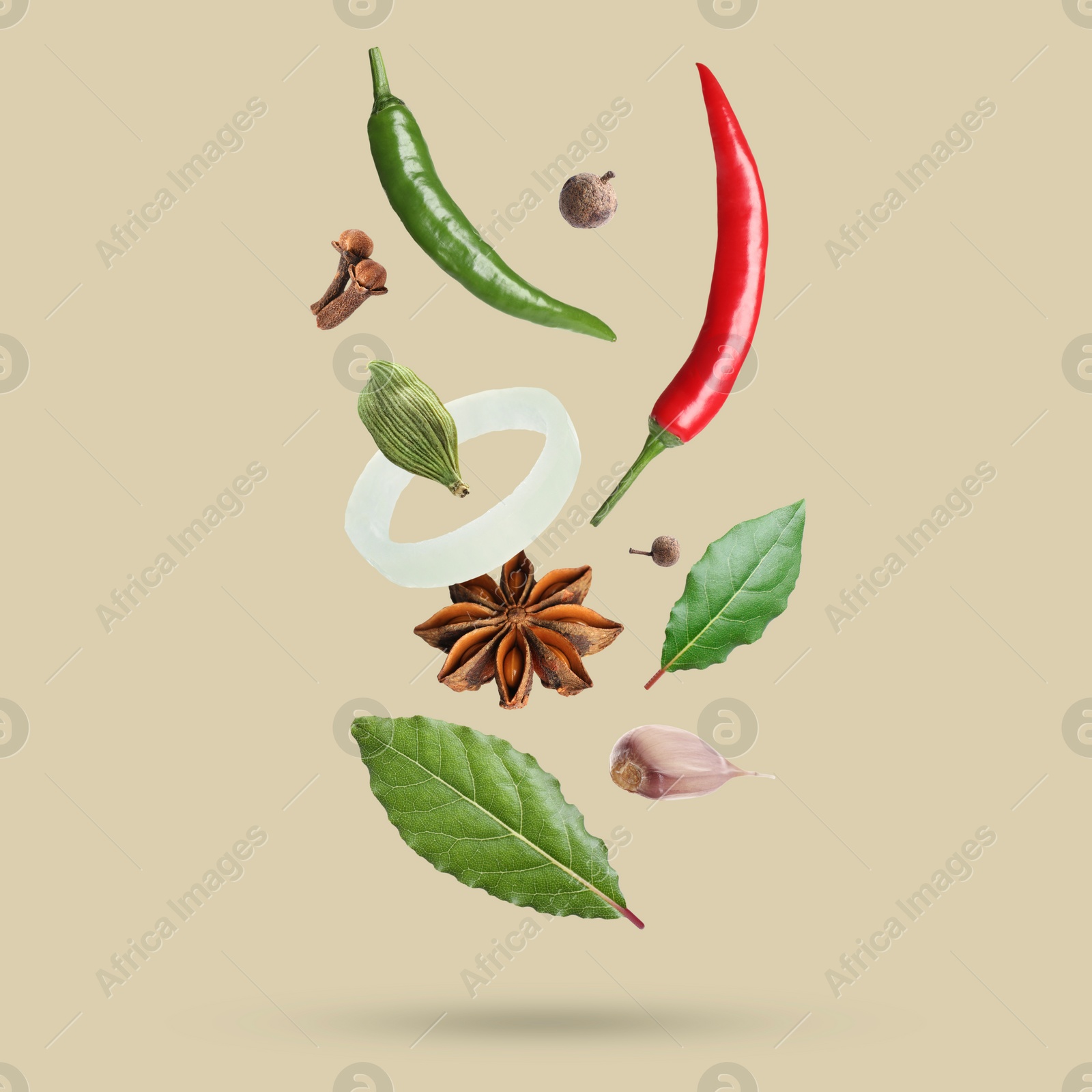 Image of Different spices falling on dark beige background