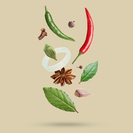 Image of Different spices falling on dark beige background