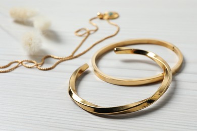 Photo of Beautiful bracelets and necklace on white wooden table, closeup