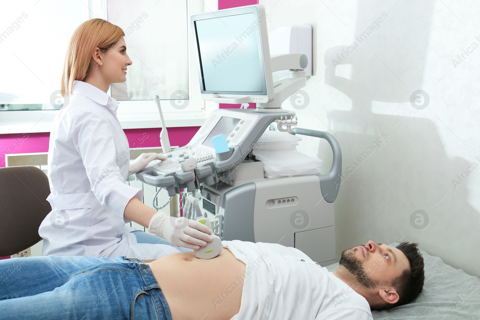 Photo of Doctor conducting ultrasound examination of internal organs in clinic. Space for text