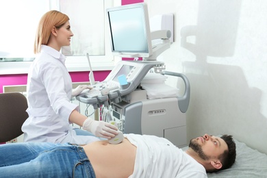 Doctor conducting ultrasound examination of internal organs in clinic. Space for text