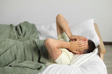 Photo of Sleepless man lying in bed at home