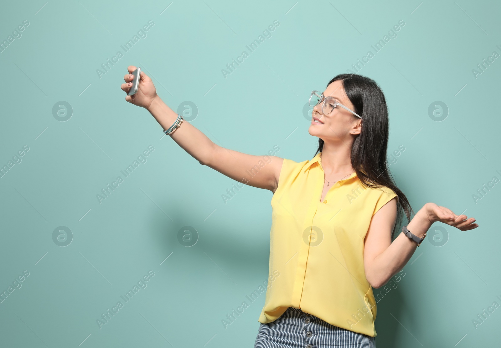 Photo of Attractive young woman taking selfie on color background