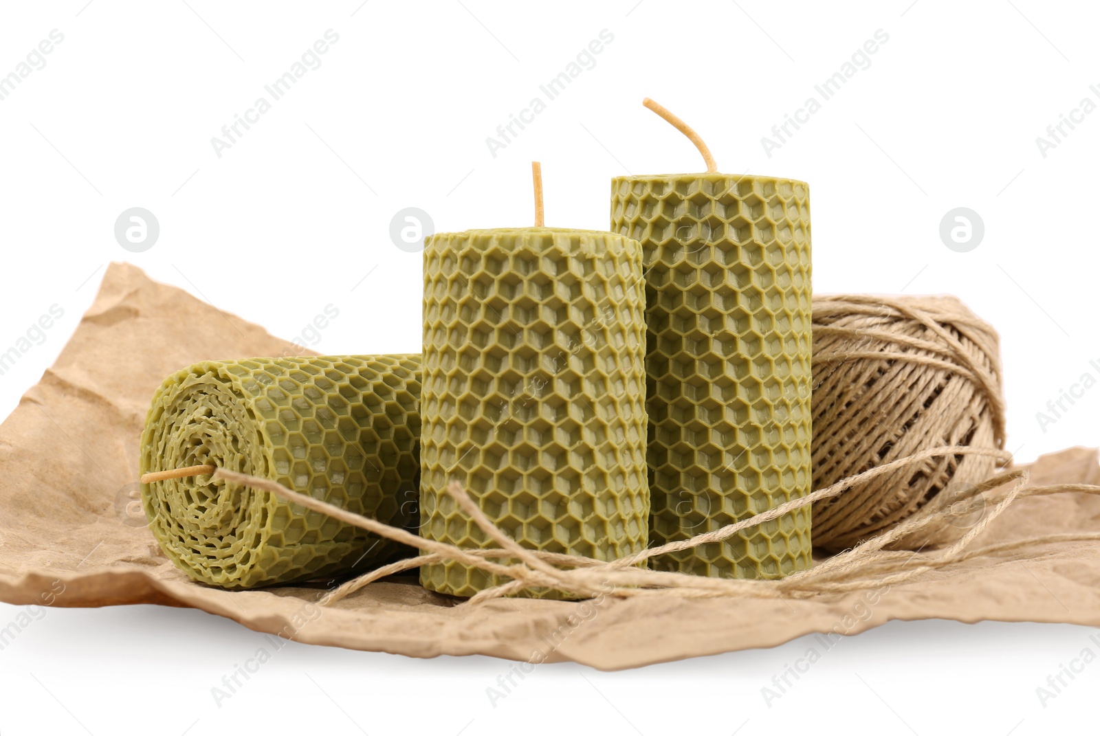 Photo of Stylish elegant beeswax candles and twine isolated on white