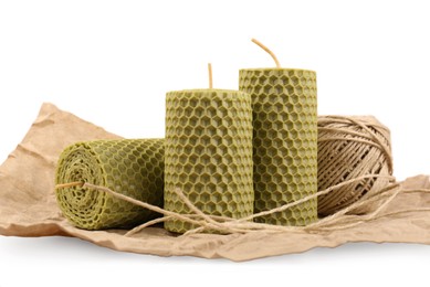 Photo of Stylish elegant beeswax candles and twine isolated on white