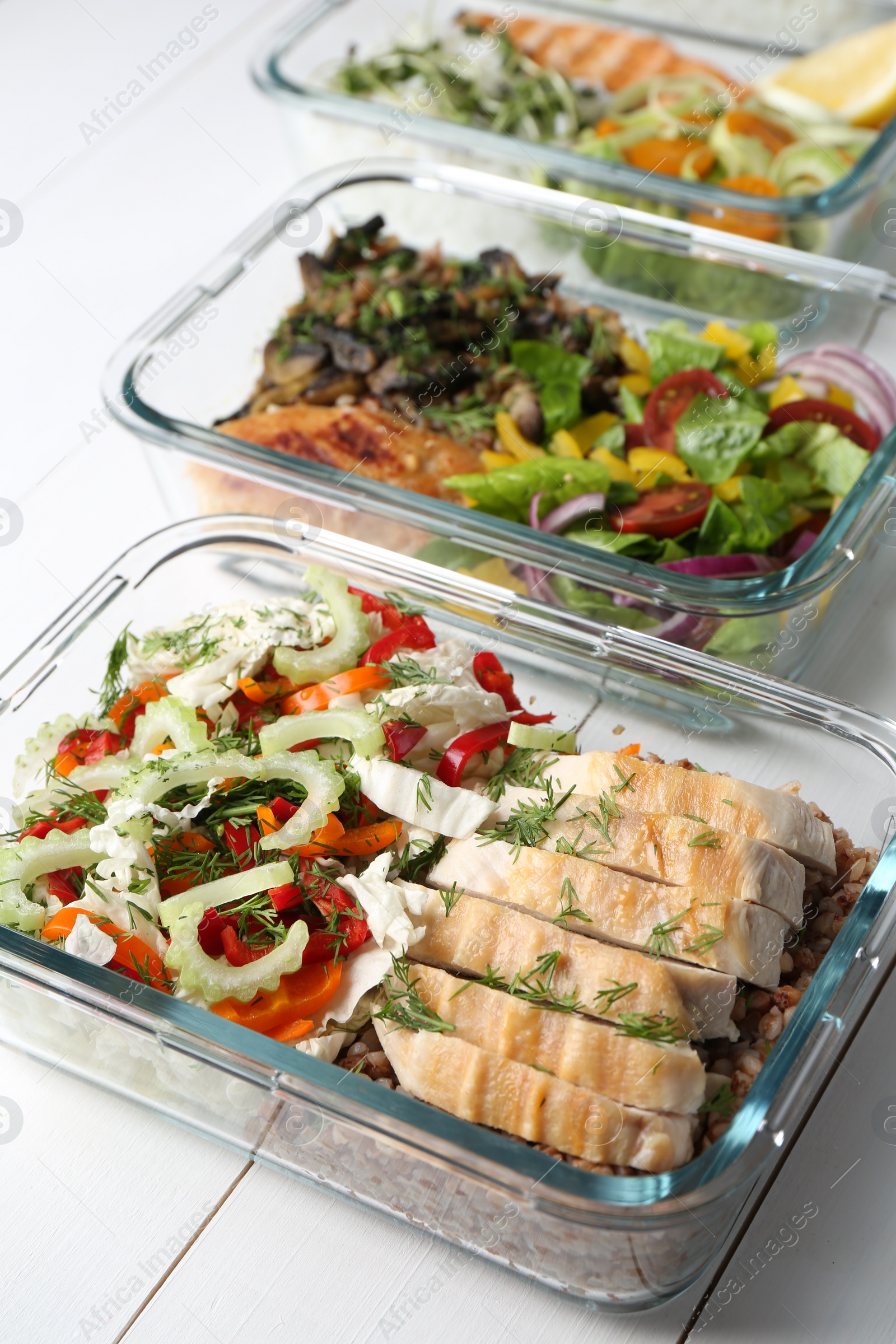 Photo of Healthy meal. Containers with different products on white wooden table