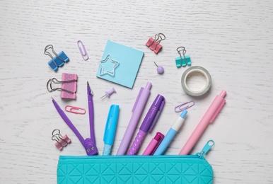 Photo of Different school stationery and pencil case on white wooden table, flat lay