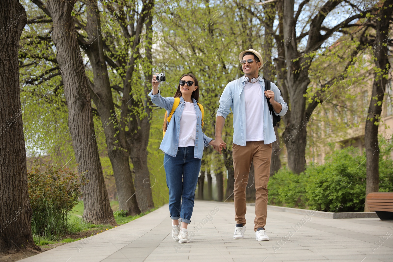 Photo of Happy couple of tourists with camera on city street