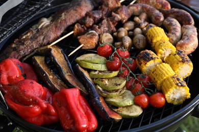 Photo of Tasty meat and vegetables on barbecue grill, closeup