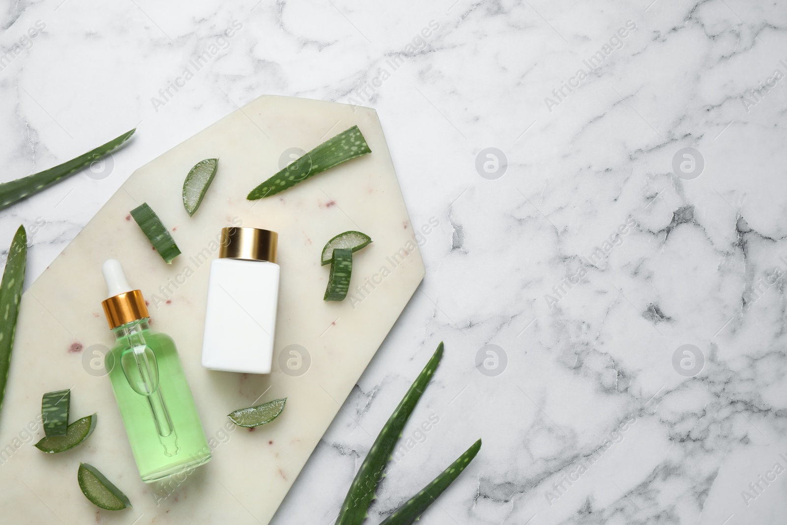 Photo of Flat lay composition with aloe vera and cosmetic products on white marble background. Space for text