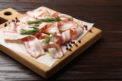 Slices of raw bacon and spices on wooden table, closeup