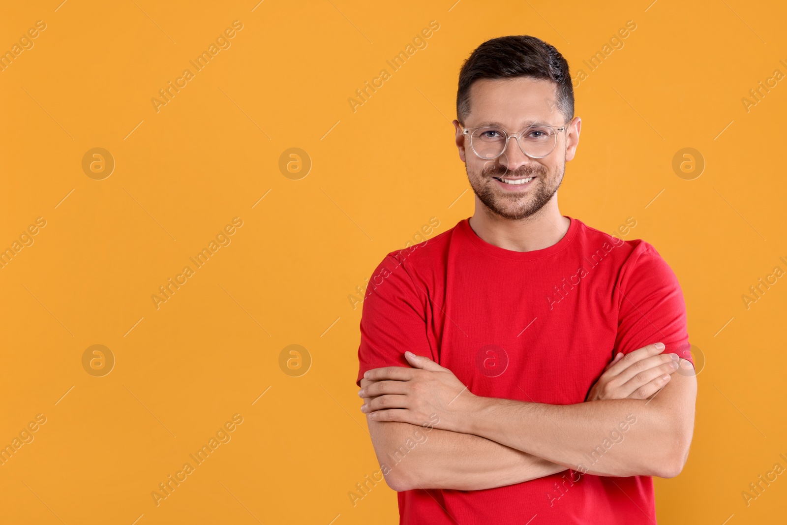 Photo of Portrait of happy man in stylish glasses on yellow background. Space for text