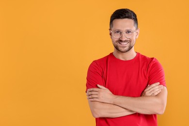 Photo of Portrait of happy man in stylish glasses on yellow background. Space for text