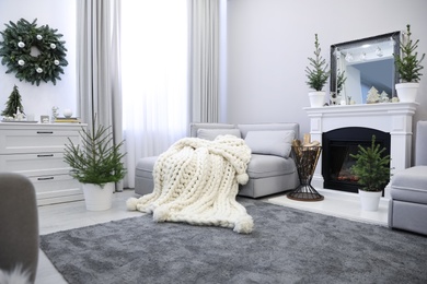 Stylish living room interior with little fir trees and Christmas decorations