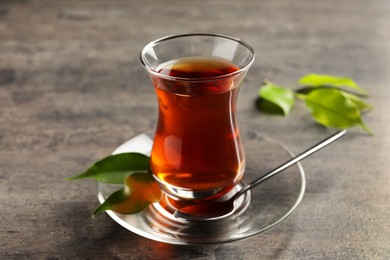 Photo of Glass with traditional Turkish tea on grey table