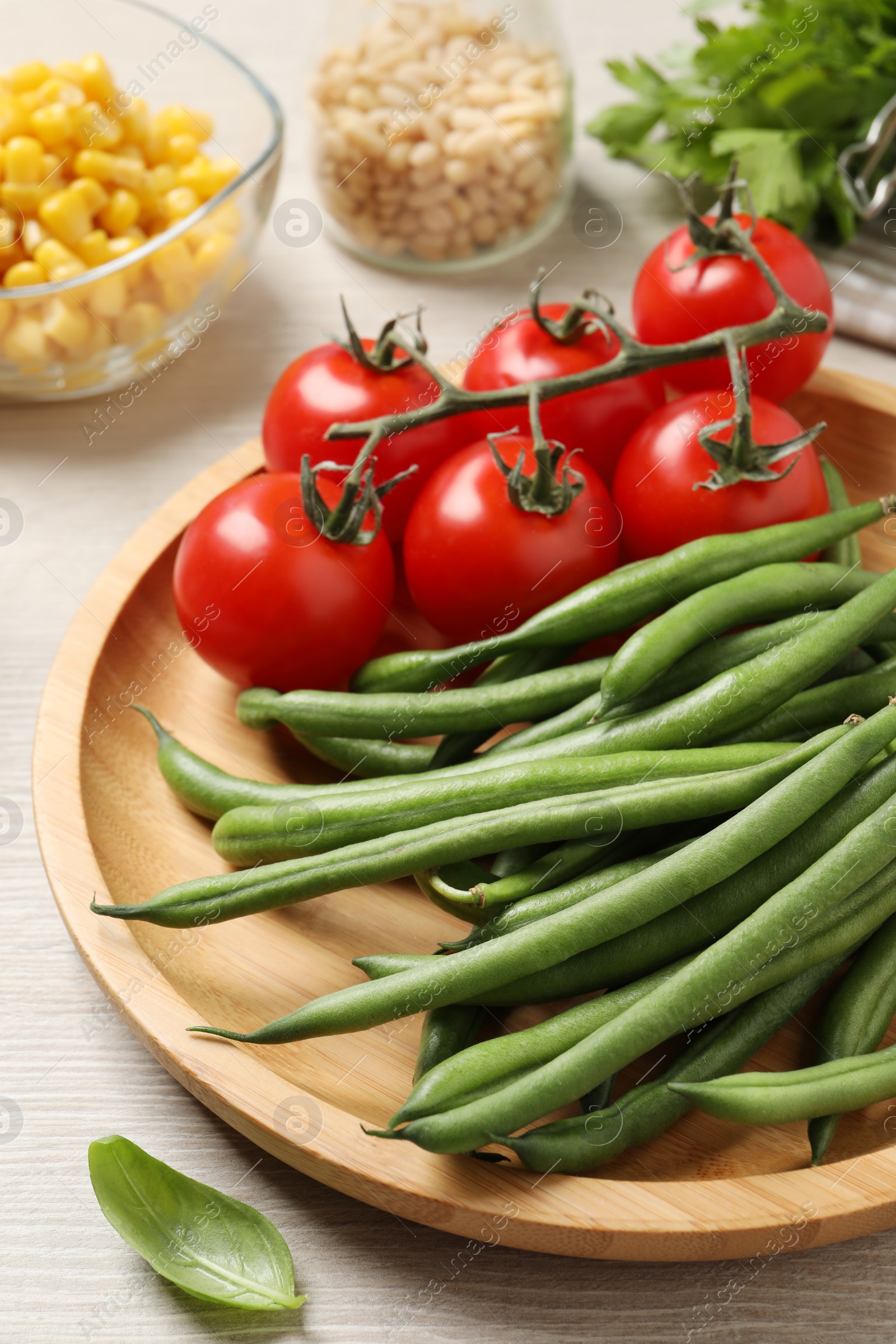 Photo of Fresh green beans and other ingredients for salad on white wooden table, closeup