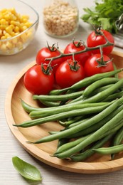 Fresh green beans and other ingredients for salad on white wooden table, closeup