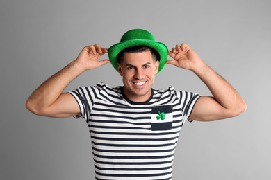 Photo of Happy man in St Patrick's Day outfit on light grey background