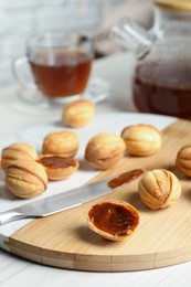 Photo of Homemade walnut shaped cookies with boiled condensed milk on white wooden table, space for text