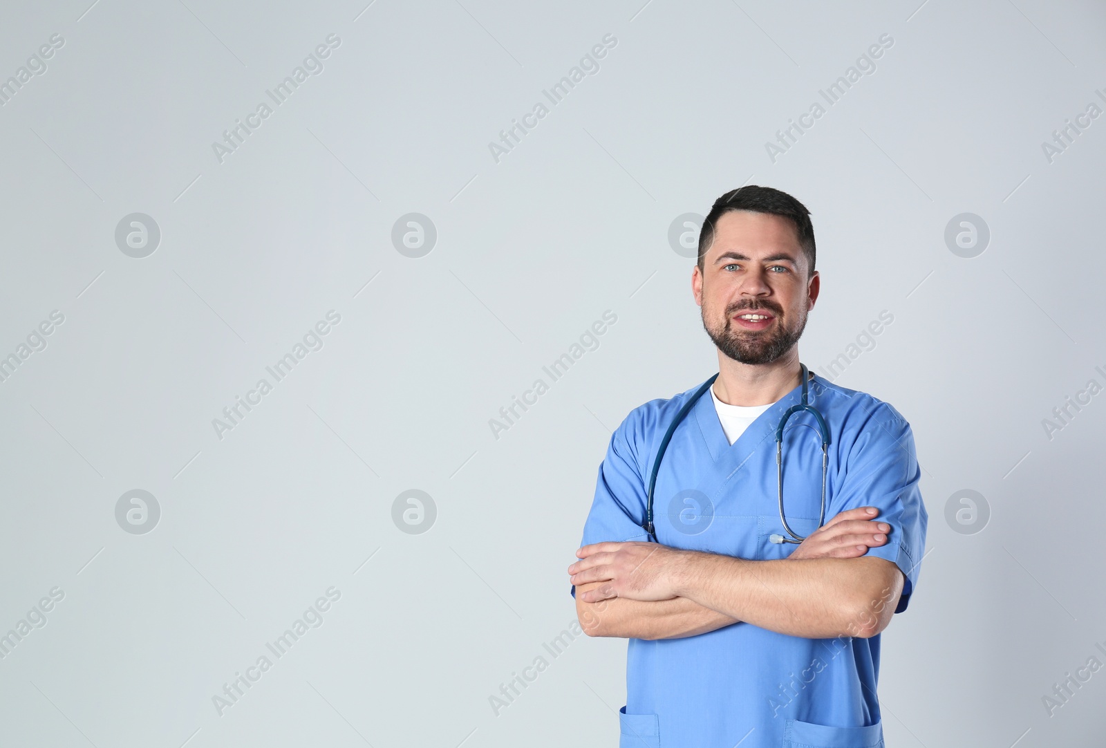 Photo of Portrait of mature doctor against light background