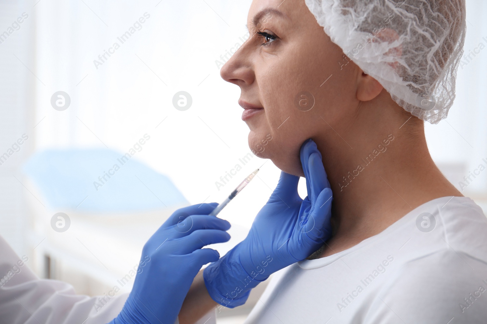 Photo of Mature woman with double chin receiving injection in clinic