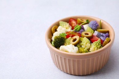 Photo of Delicious salad with cauliflower, tomato and olives on white table, closeup. Space for text